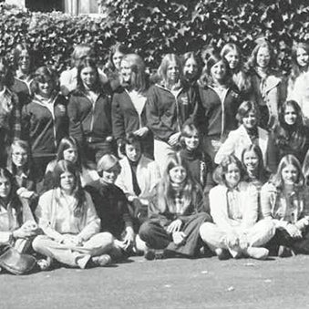 A large group of people pose together outdoors in a black-and-white photograph.