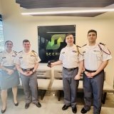 Isabella Ross, Jayden LaVecchia, Brendan Coyne, and Ahmed Mohammad stand in front of the Seerist logo on the wall in Seerist HQ; LaVecchia is displaying the trophy in his right hand.