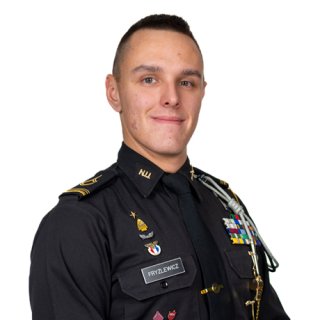 Person in a dark military-style uniform with pins, ribbons, shoulder cords, and a name tag reading FRYZLEWICZ.