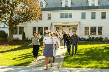 Norwich University students leading families on a campus tour outside the Roberts Hall Admissions Office.