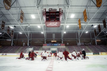Norwich University women’s ice hockey team kneels at center ice during practice at Kreitzberg Arena before traveling to the NCAA Frozen Four