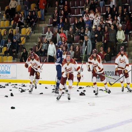 Norwich cadets skate on the ice after scoring a goal, the ice littered with donated socks.
