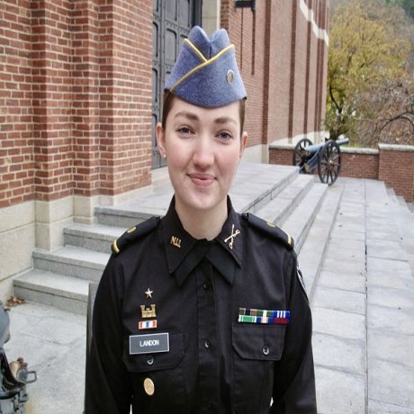 A cadet smiles in a headshot, wearing a Navy uniform.