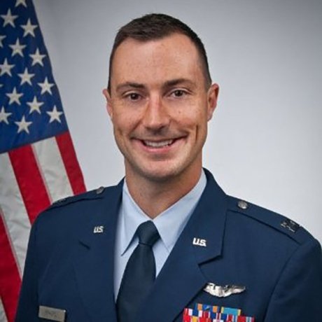 A man in his Air Force uniform smiles in professional headshot.