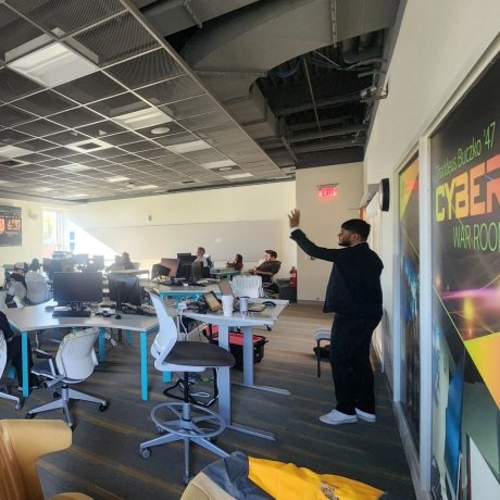 A student in a suit presents to a class of students.