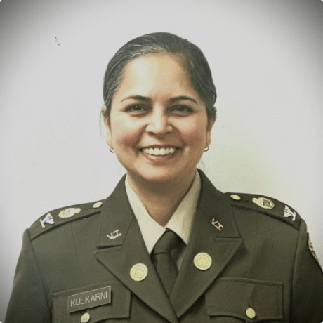 A person in military uniform smiles in formal portrait.