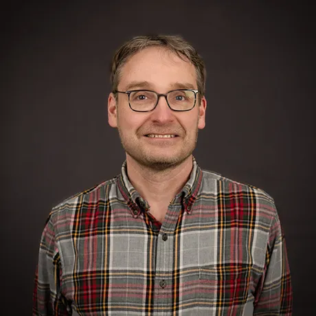Illari Vihinen in plaid shirt with glasses