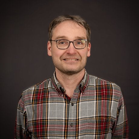 Illari Vihinen in plaid shirt with glasses