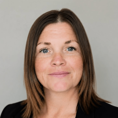 Portrait of a person against a plain gray background.