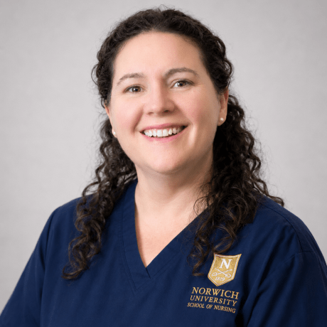 Person wearing glasses and navy Norwich School of Nursing scrubs.