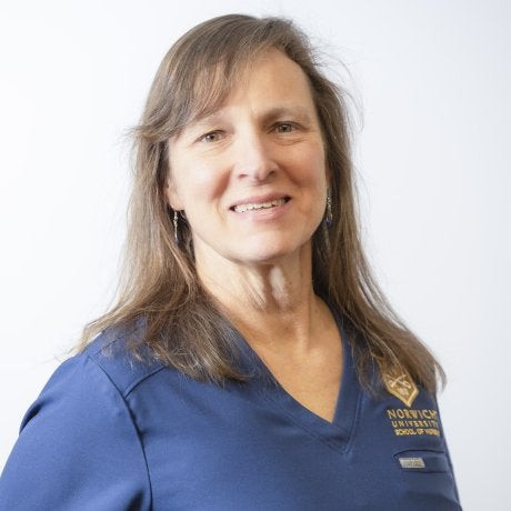 A person in a blue shirt poses against a plain white background.