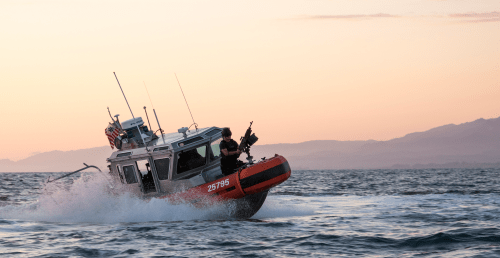 Coast Guard patrol boat cruising through ocean waters.