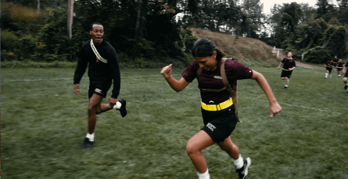 Rooks wearing weighted gear run across a grassy field