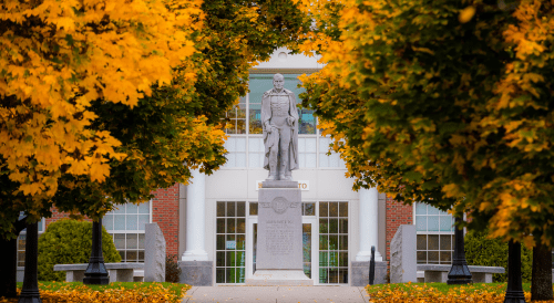 Statue of Captain Alden Partridge surrounded by fall foliage.