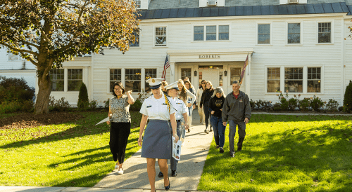 Norwich University students leading families on a campus tour outside the Roberts Hall Admissions Office.