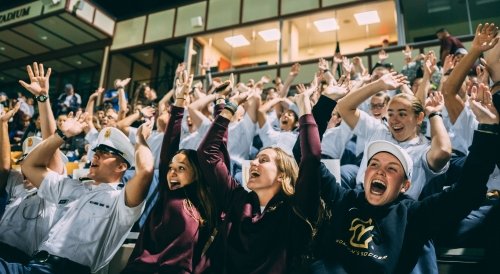 Students cheering for a Norwich team at the Harmon Stadium on Sabine Field.