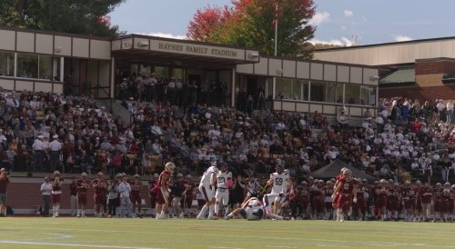 Football players compete on the field as fans fill the stands at Haynes Family Stadium.