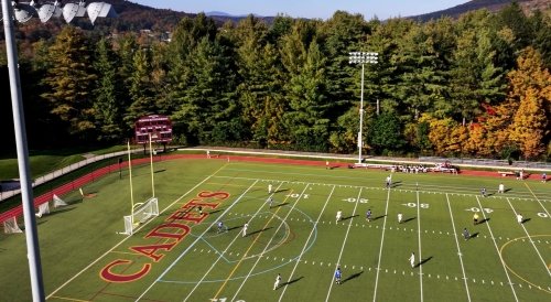Aerial view of a soccer game on a field labeled Cadets surrounded by trees.