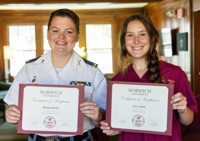 Two Norwich University students holding acceptance certificates.