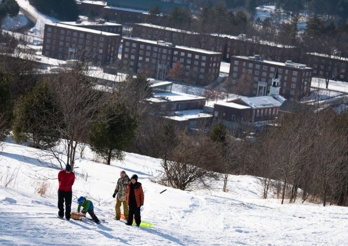 Sledding Party at Shaw Outdoor Center with Norwich Campus in background