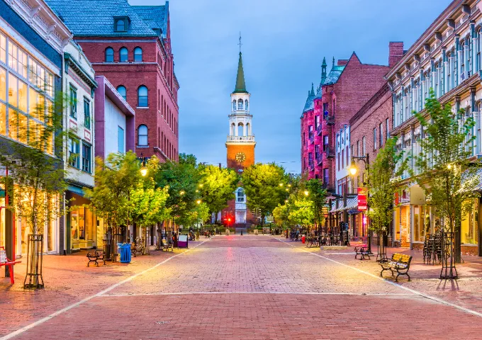 View down Burlington's Church Street at dusk, lined with local shops and restaurants.