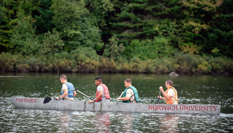 Norwich Civil Engineering majors in a concrete canoe that they built.