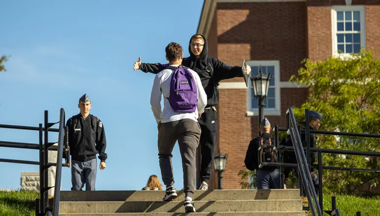 Civilian students embracing on staircase near WCC.