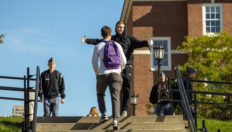 Civilian students embracing on staircase near WCC.