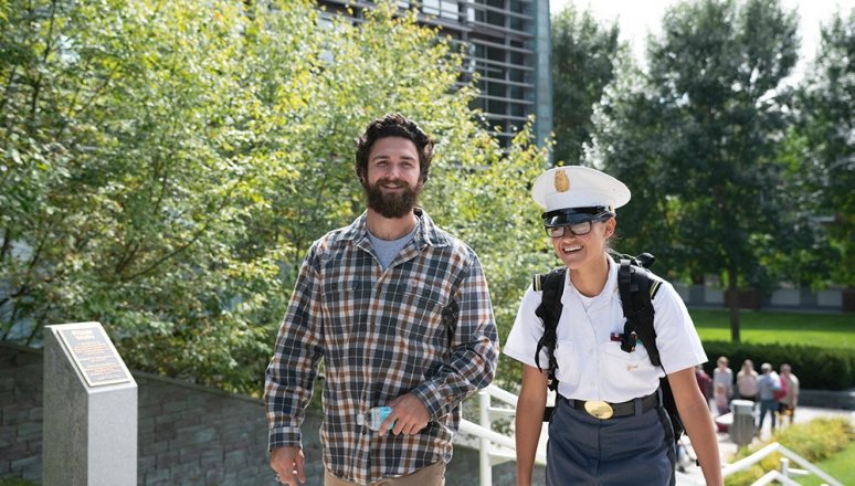 Corps student and civilian student walking together on campus.
