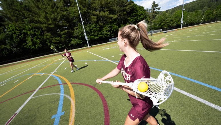 Women's lacrosse players passing the ball on Sabine Field.