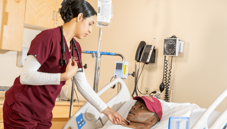 Nursing student checking on Simulation patient.