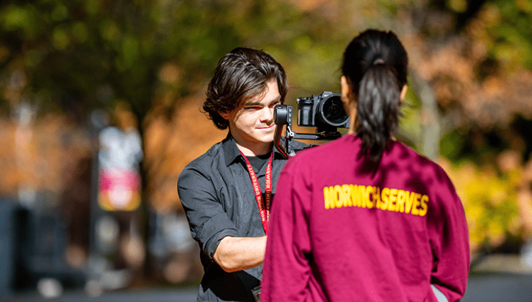 Student filming interview with another student on campus.
