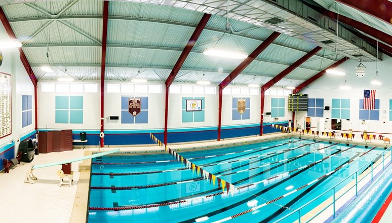 Goodyear Pool at Norwich University: six-lane, 25-yard indoor swimming facility with blue water, lane dividers, and stadium seating.
