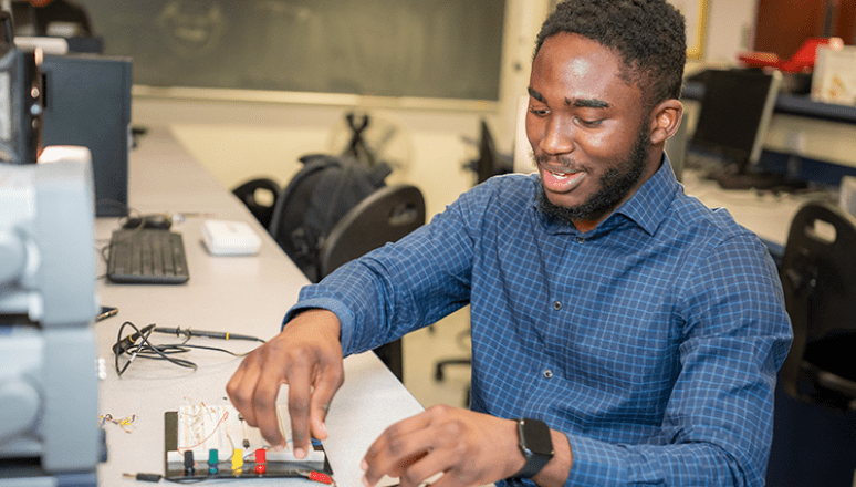 Student working on electrical computer hardware.