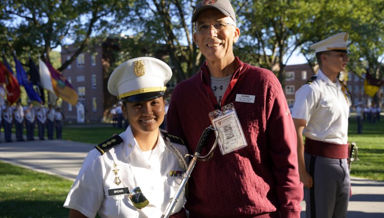 Band member stands with an alumnus outside.