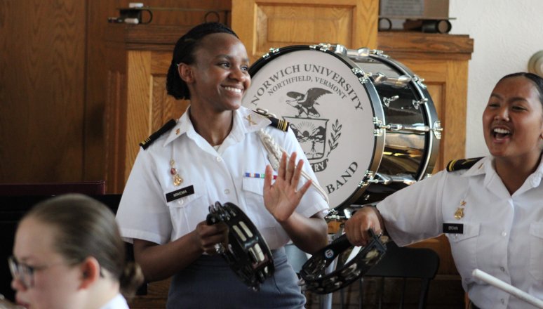 Band members pose indoors with a drum.