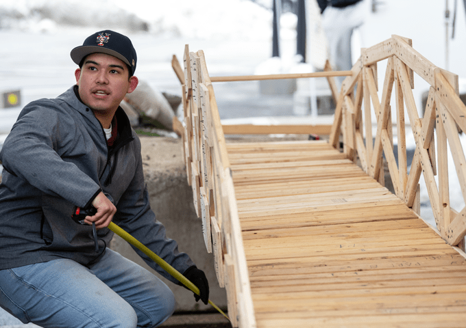 Norwich civil engineering student working on a wooden bridge