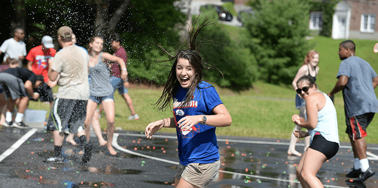 Orientation leader laughing during event outside.