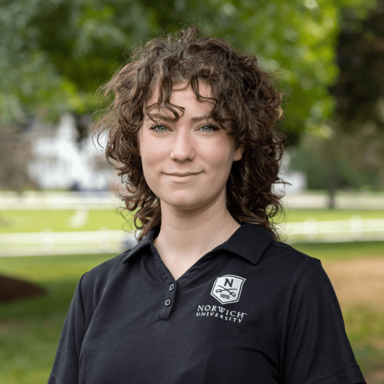 Portrait photo of Emma outside wearing a black Norwich polo.