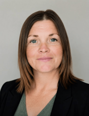 Portrait of a person against a plain gray background.