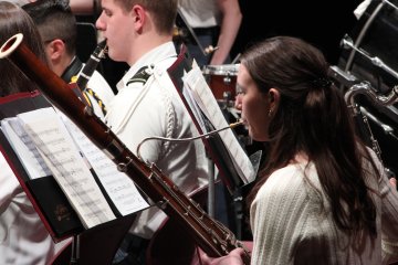 Band members play woodwinds at a concert.