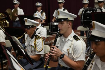 Students play clarinets during a band performance.