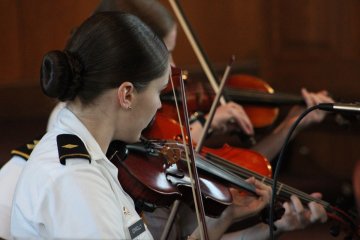 Cadet violinists perform on stage.