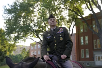 Commandant seated on a horse outdoors.