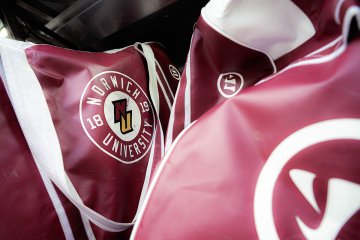 Close-up of Norwich University women’s ice hockey equipment bags with Norwich logo packed for NCAA Frozen Four travel