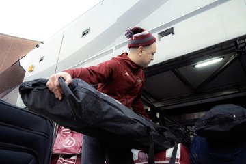Norwich University hockey staff load long equipment bags into team bus storage before departing for NCAA Frozen Four