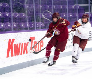 Norwich players in red and white jerseys skate in pursuit of puck during high-intensity practice drill 